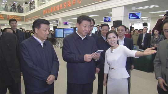 在新華社新聞信息發(fā)稿中心,習(xí)近平通過手機移動平臺為新聞工作者點贊。