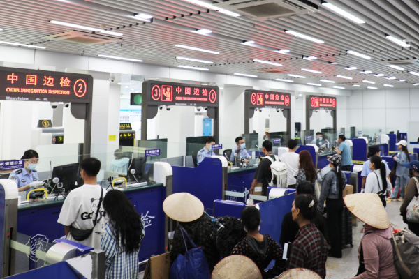 旅客在通道排隊等待查驗通關。周榮寶攝