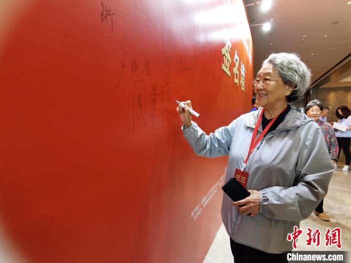 圖為中國新聞社原副社長周秉德簽字留念?！∑钤鲚?攝