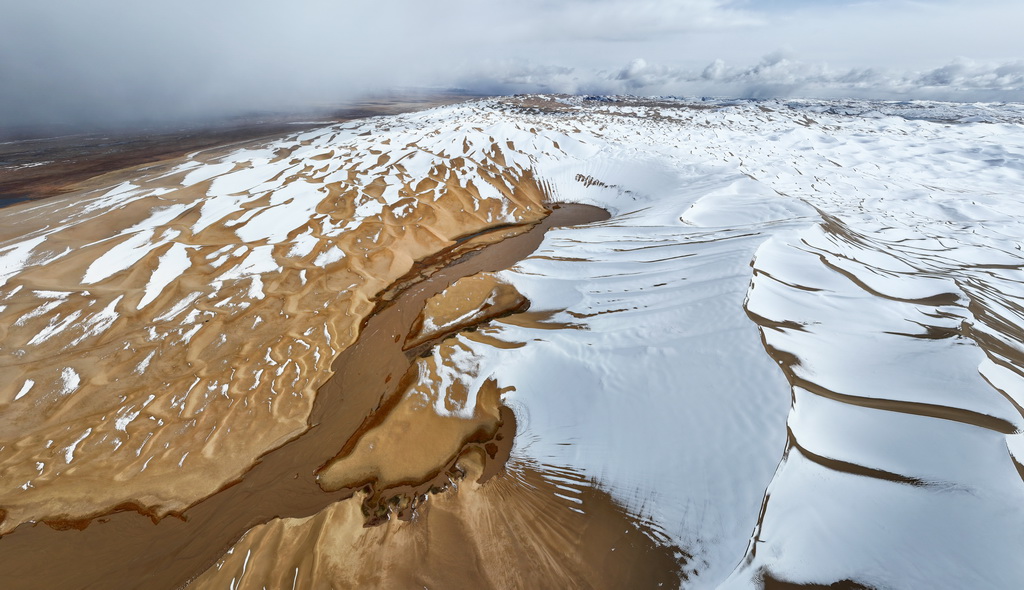 2023年10月16日在新疆阿爾金山國(guó)家級(jí)自然保護(hù)區(qū)拍攝的白雪覆蓋的大沙子泉（無(wú)人機(jī)照片）。新華社記者 李響 攝