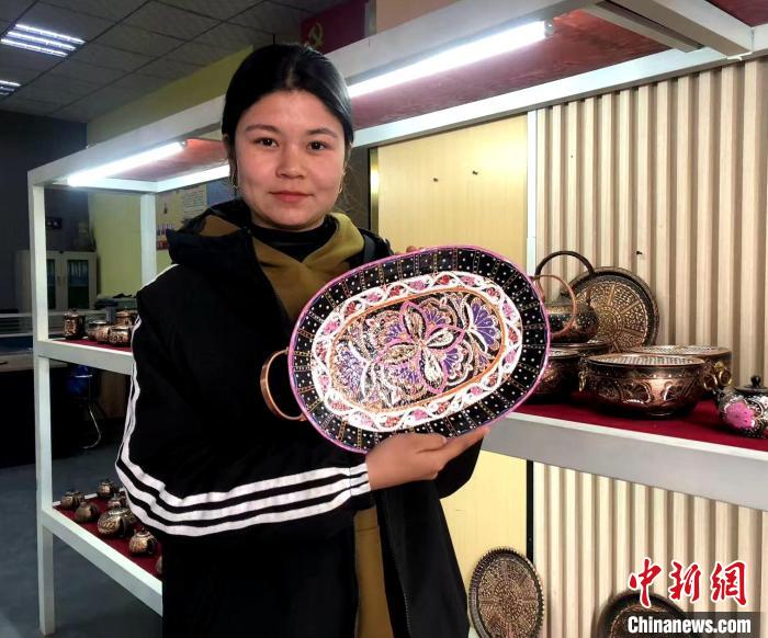 迪麗努爾·艾則孜展示鑲有艾德萊絲綢花紋的托盤。陶拴科 攝