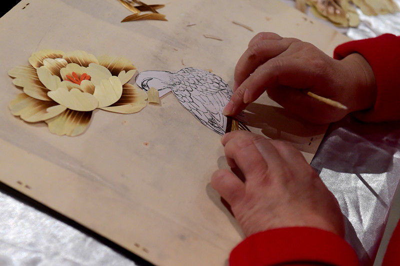  12月2日，在埃及開羅，一名中國手工藝人在“甘肅文化周”非物質(zhì)文化遺產(chǎn)展上制作秸稈畫。 （新華社記者趙丁喆攝）